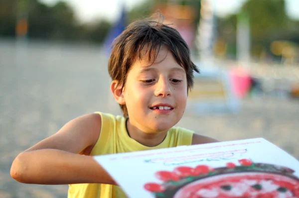 Menino enquanto come pizza takeaway em Sunset Beach — Fotografia de Stock