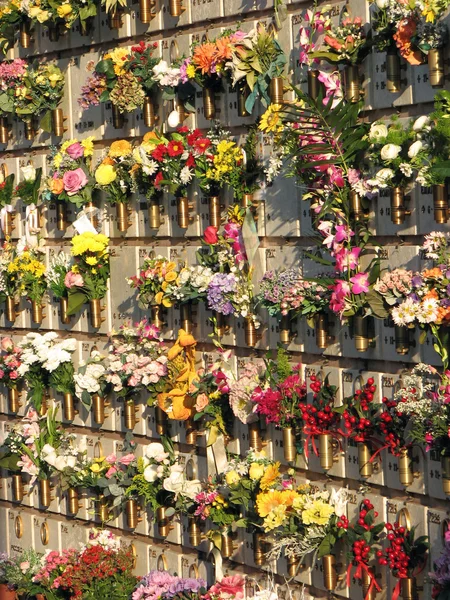 Lápides e túmulos no cemitério com muitas flores — Fotografia de Stock