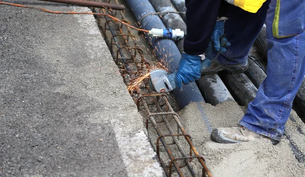 Faíscas quando o trabalhador cortar um pedaço de ferro com um flexível — Fotografia de Stock