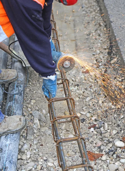 Faíscas quando o trabalhador cortar um pedaço de ferro com um flexível — Fotografia de Stock