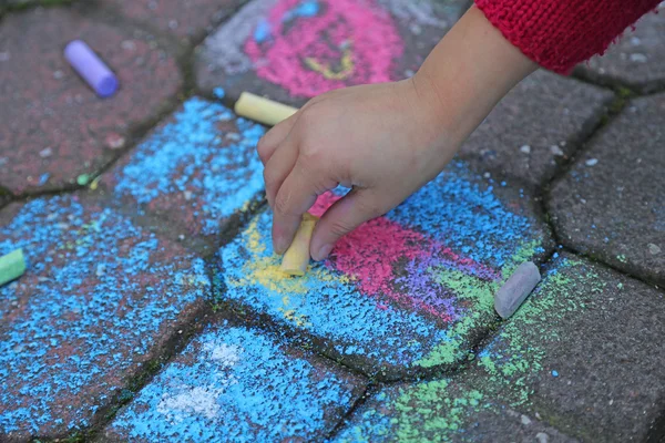 Young girl draws with the colourful chalks — Stock Photo, Image