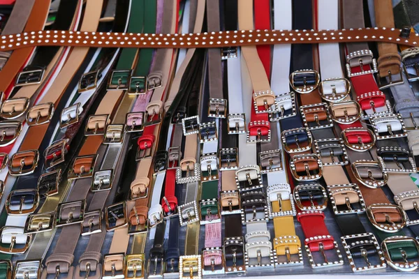 Many men's leather belts and shoes for sale at flea market — Stock Photo, Image