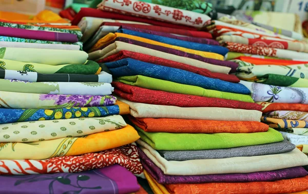 Beaucoup de nappes en tissu coloré à vendre sur le marché de la ville — Photo