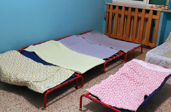 Slaapzaal met kleine bedden voor kinderen in een kleuterschool — Stockfoto