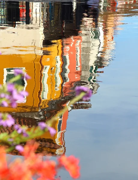 Tükrözi a házak Burano sziget és a virágok — Stock Fotó