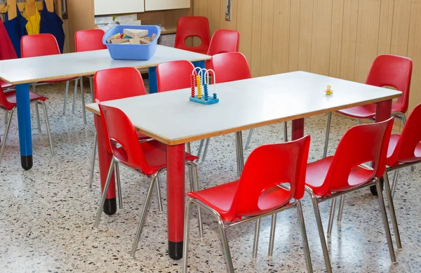 Berçário de sala de aula com cadeiras e mesas vermelhas — Fotografia de Stock
