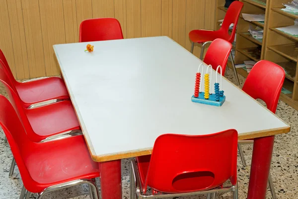 Table avec chaises rouges d'une classe d'école pour enfants — Photo