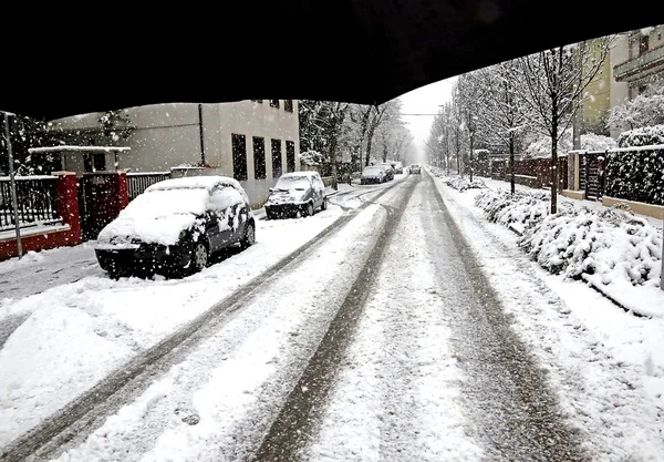 Stadens huvudgata med vit snö och en svart paraply — Stockfoto