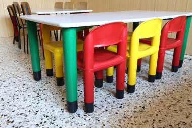 plastik sandalye ve kreş sınıfında küçük tablolar