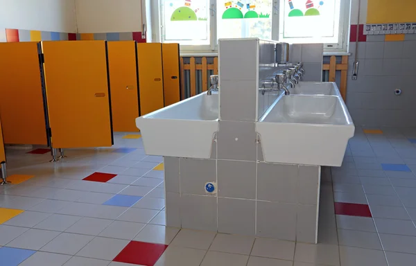 Badkamer van de kleuterschool met keramische wastafels — Stockfoto