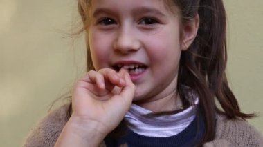 küçük kız elini tarafından sallanır diş ile