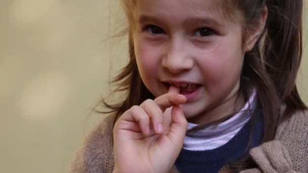 Bambina con il dente che penzola per mano — Video Stock