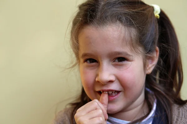 Little girl with the front tooth dangles — Stock Photo, Image