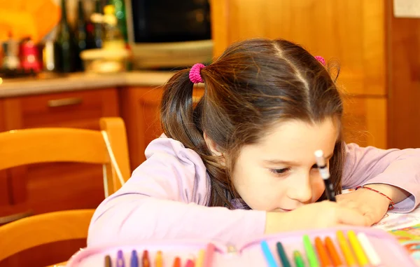 Menina bonito escreve em seu caderno em casa — Fotografia de Stock