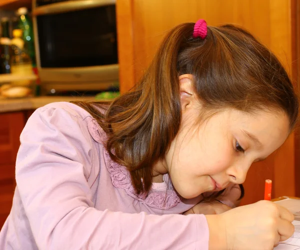 Küçük kız evde defterini yazar — Stok fotoğraf