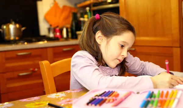 Niña escribe en su cuaderno en casa — Foto de Stock