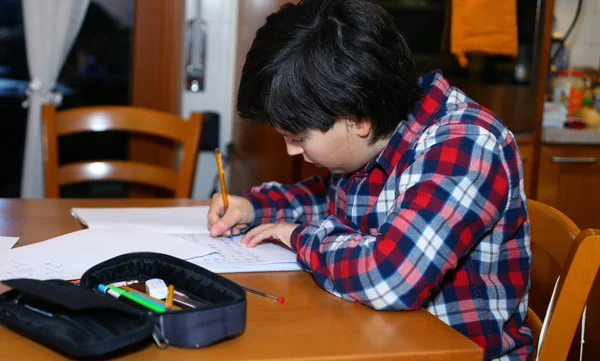 Chłopiec ma zadanie domowe w jego domu — Zdjęcie stockowe