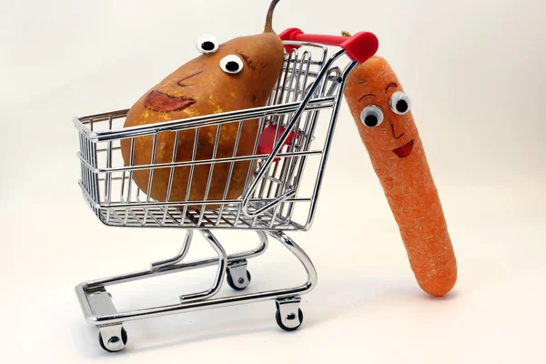 Zanahorias empuja el carrito de la compra con una pera con los ojos — Foto de Stock