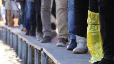 Venedik'te Saint Mark Meydanı'nda podyum üzerinde yürüyen insanlar