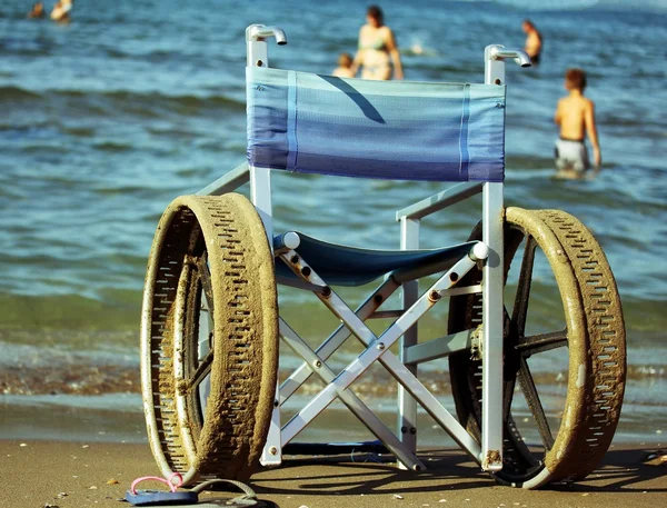 Silla de ruedas con ruedas perforadas para nadar en el mar de peo — Foto de Stock