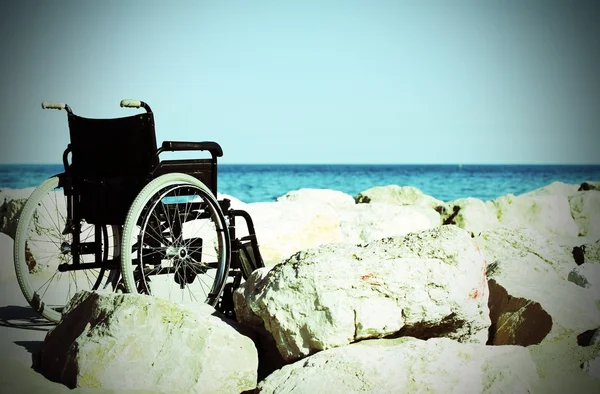 在阳光明媚的夏日, 在蔚蓝的海边坐轮椅 — 图库照片