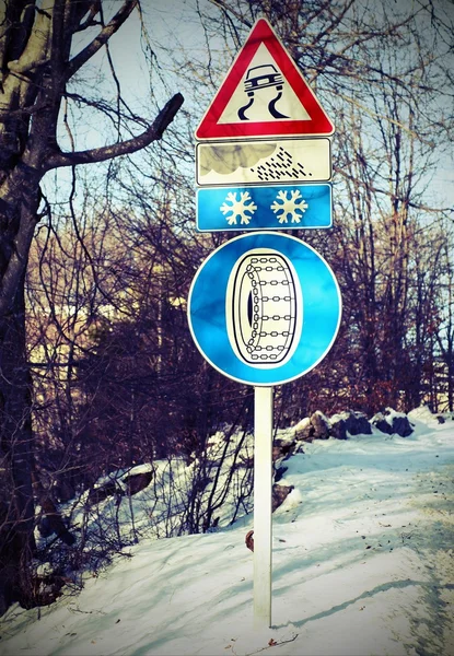 Street sign and an indication of the road slippery — Stock Photo, Image