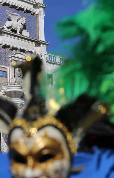 Torre del reloj con león alado y una máscara veneciana — Foto de Stock