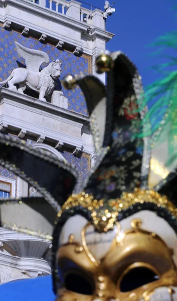 Torre de relógio com leão alado e uma máscara veneziana — Fotografia de Stock