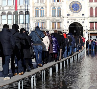 Venedik insanlar yüksek gelgit sırasında geçit yükseltilmiş üzerinde yürüyen