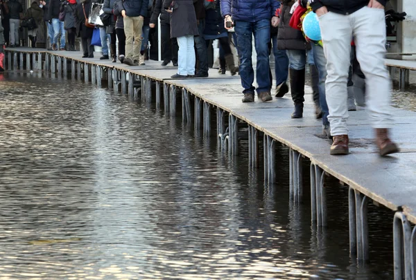 Venecia personas caminando en la pasarela elevada durante la marea alta — Foto de Stock