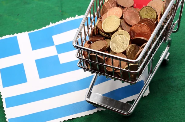 Warenkorb voller Eurogeld über griechischer Flagge — Stockfoto