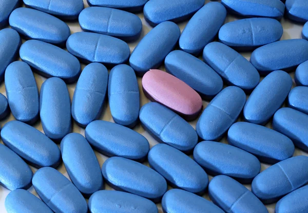 质地的蓝色垫与独特的粉红药丸 — 图库照片