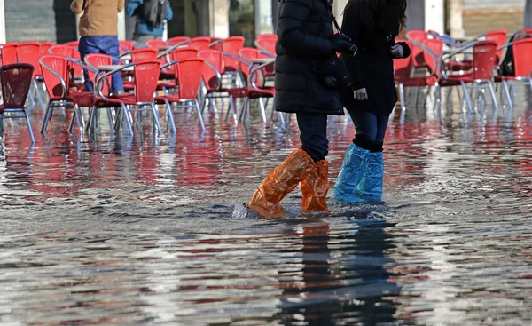 Lidé s legínami a boty za přílivu v Benátkách — Stock fotografie