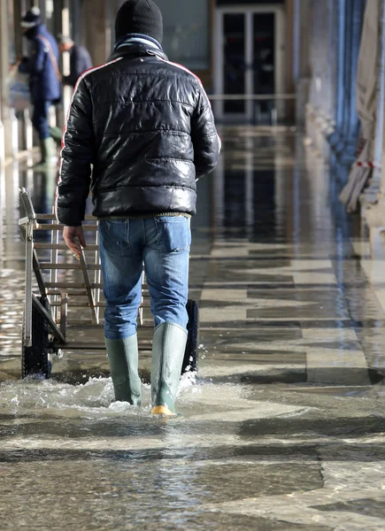 Operaio con il carrello di trasporto in alta marea a Venezia — Foto Stock