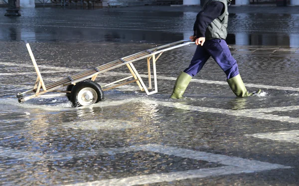 ヴェネツィアで高潮で交通のショッピングカートと労働者 — ストック写真