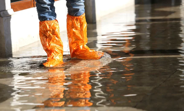 Woman with gaiters at high tide in Venice — Stock Photo, Image