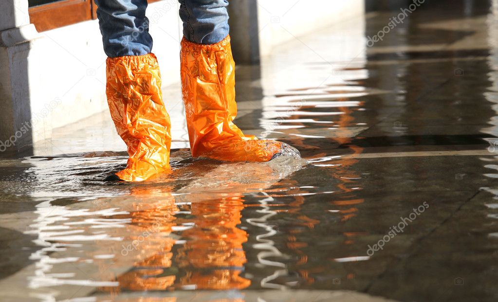 woman with gaiters at high tide in Venice