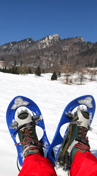 Homem com azul moderno snowshoes na montanha — Fotografia de Stock