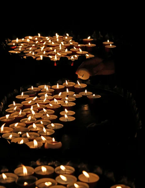 Пожилая женщина в молитве и зажгла свечу — стоковое фото