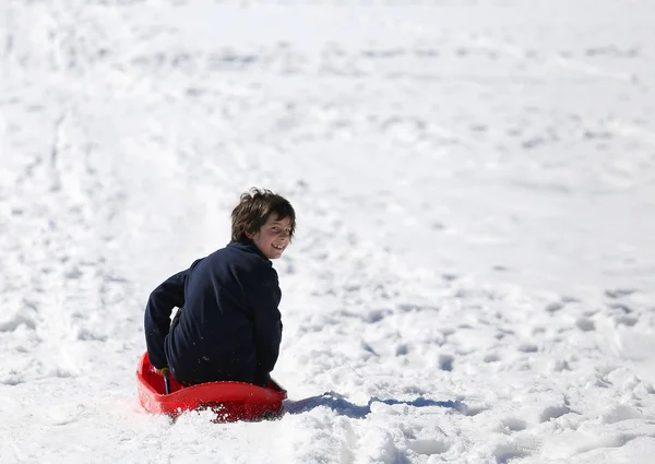 Child plays with bob in the white snow — Stock Photo, Image