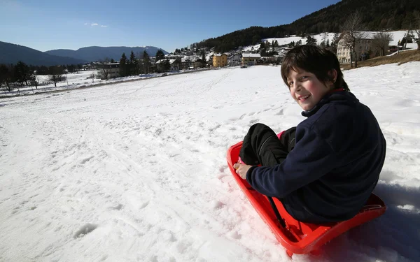 Child plays with bob in the white snow — Stock Photo, Image