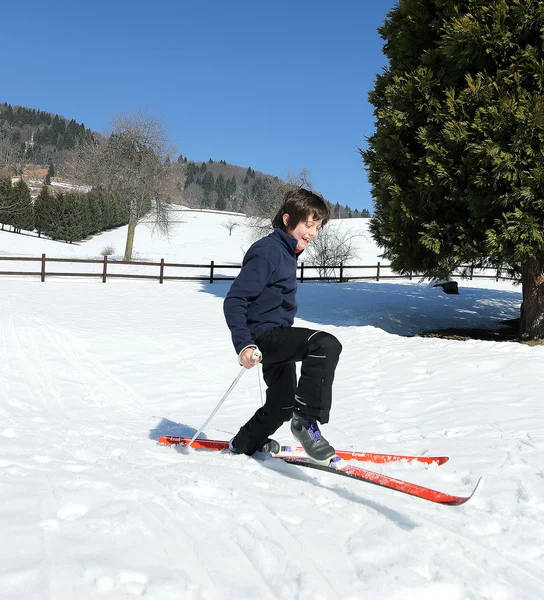 Un jeune garçon tombe avec des skis de fond — Photo