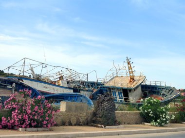 broken ancient shipwrecks after the disembarkation of refugees clipart