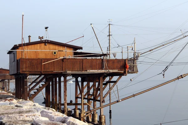Tepedeki eve balık ağlarına balıkçılar ve deniz tarafından — Stok fotoğraf