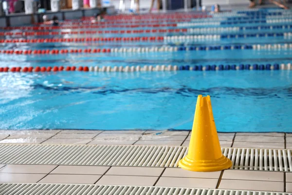 Segnale cono pavimento bagnato nella piscina coperta — Foto Stock