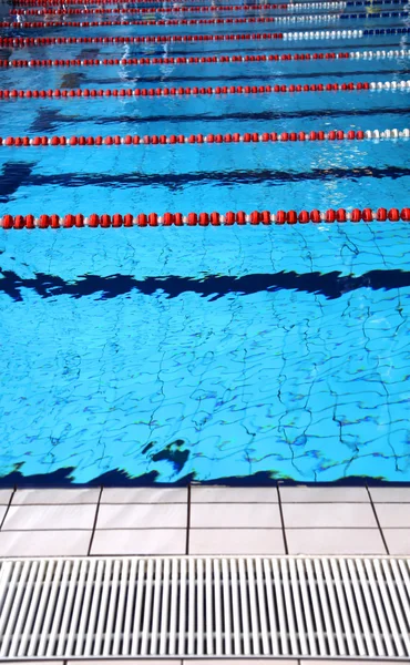 Hallenbad mit blauem Wasser und Schwimmbahnen — Stockfoto