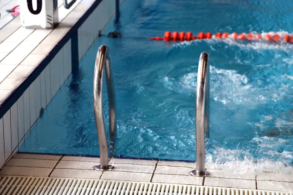 Escaleras para salir de la piscina olímpica Imágenes De Stock Sin Royalties Gratis