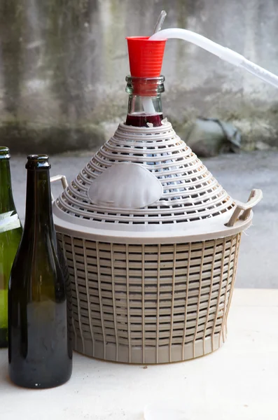 Bouteille de vin maison dans le jardin avec des bouteilles en verre — Photo