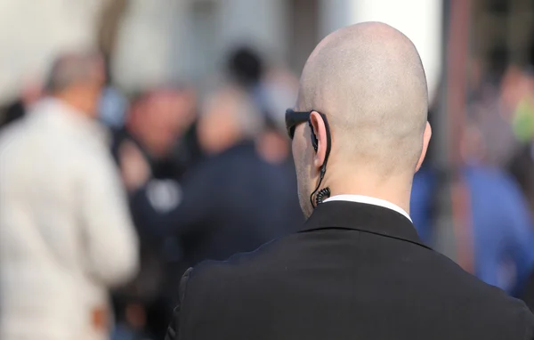 Robust security guard with the headset and black glasses — Stock Photo, Image