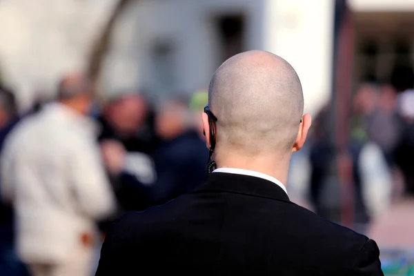 Robust säkerhetsvakt med mörka glasögon och en radioheadset — Stockfoto